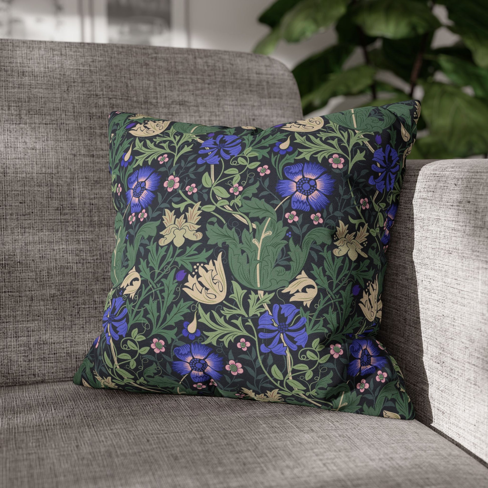 Floral patterned pillow on a gray sofa with a blurred background