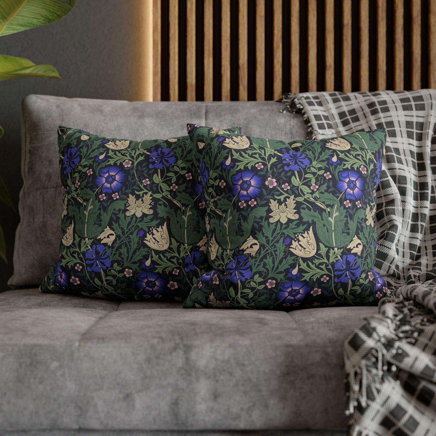 Floral patterned cushions on a gray sofa with a wooden headboard in the background.