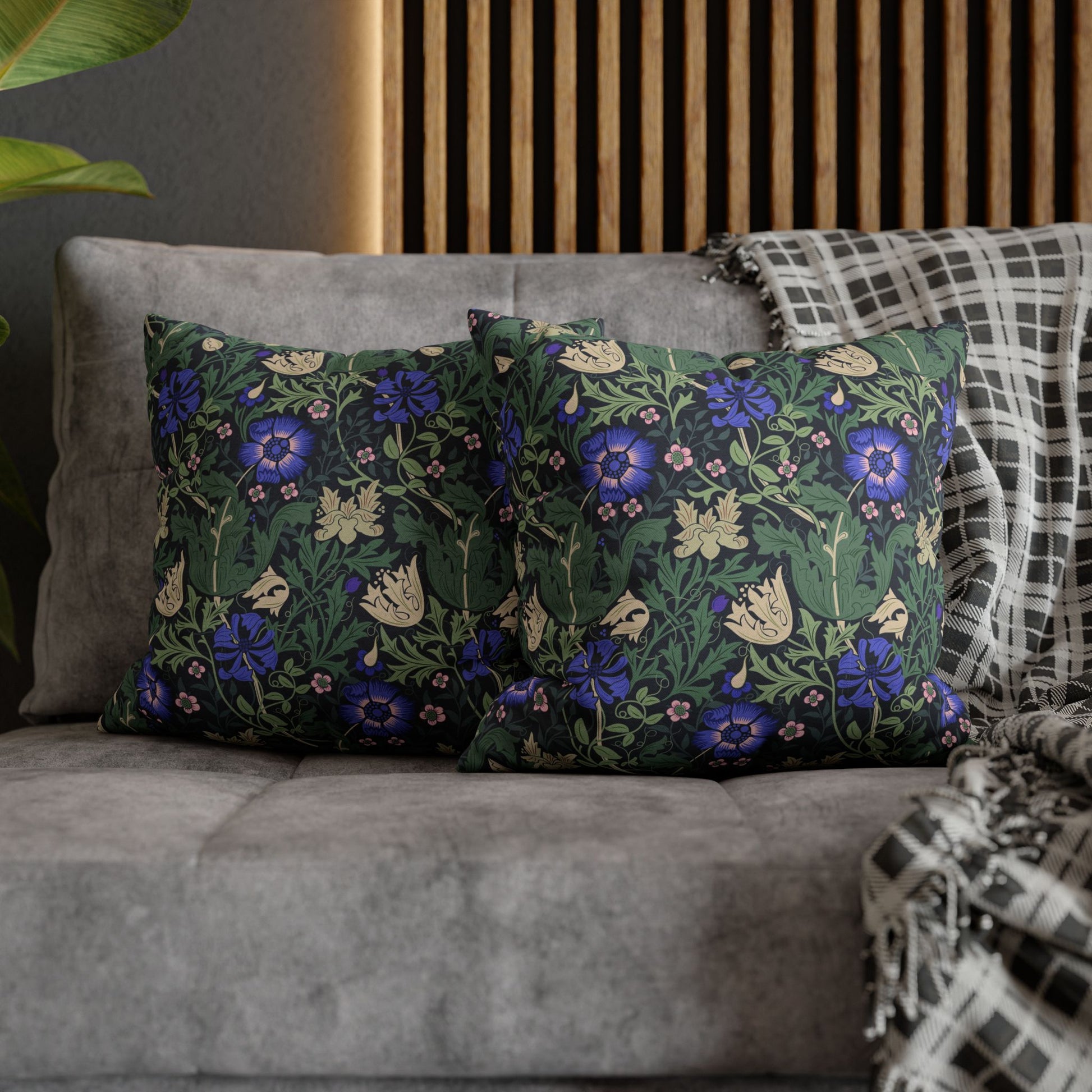 Floral patterned cushions on a gray sofa with a wooden headboard in the background.