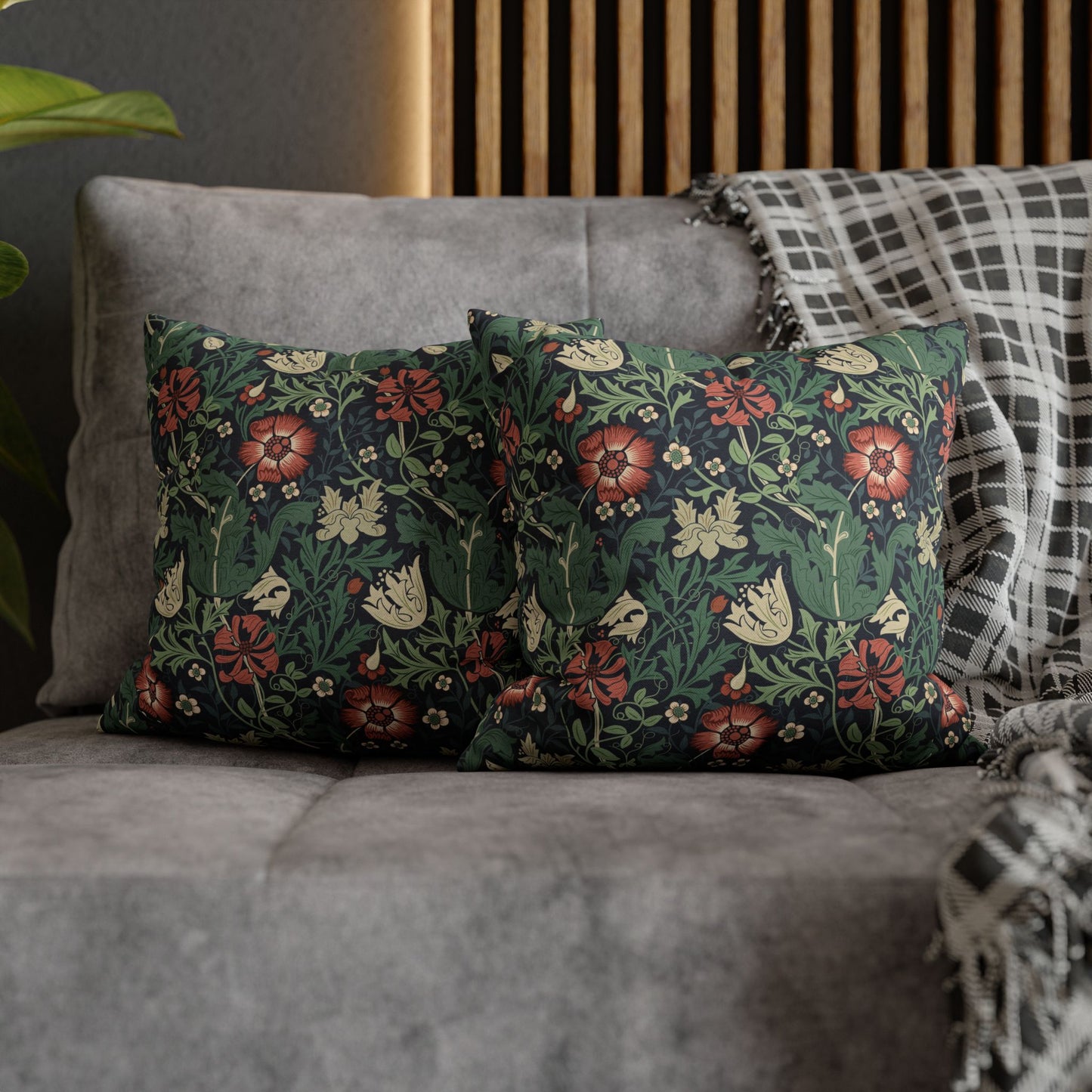 Floral patterned cushions on a gray sofa with a wooden headboard in the background.