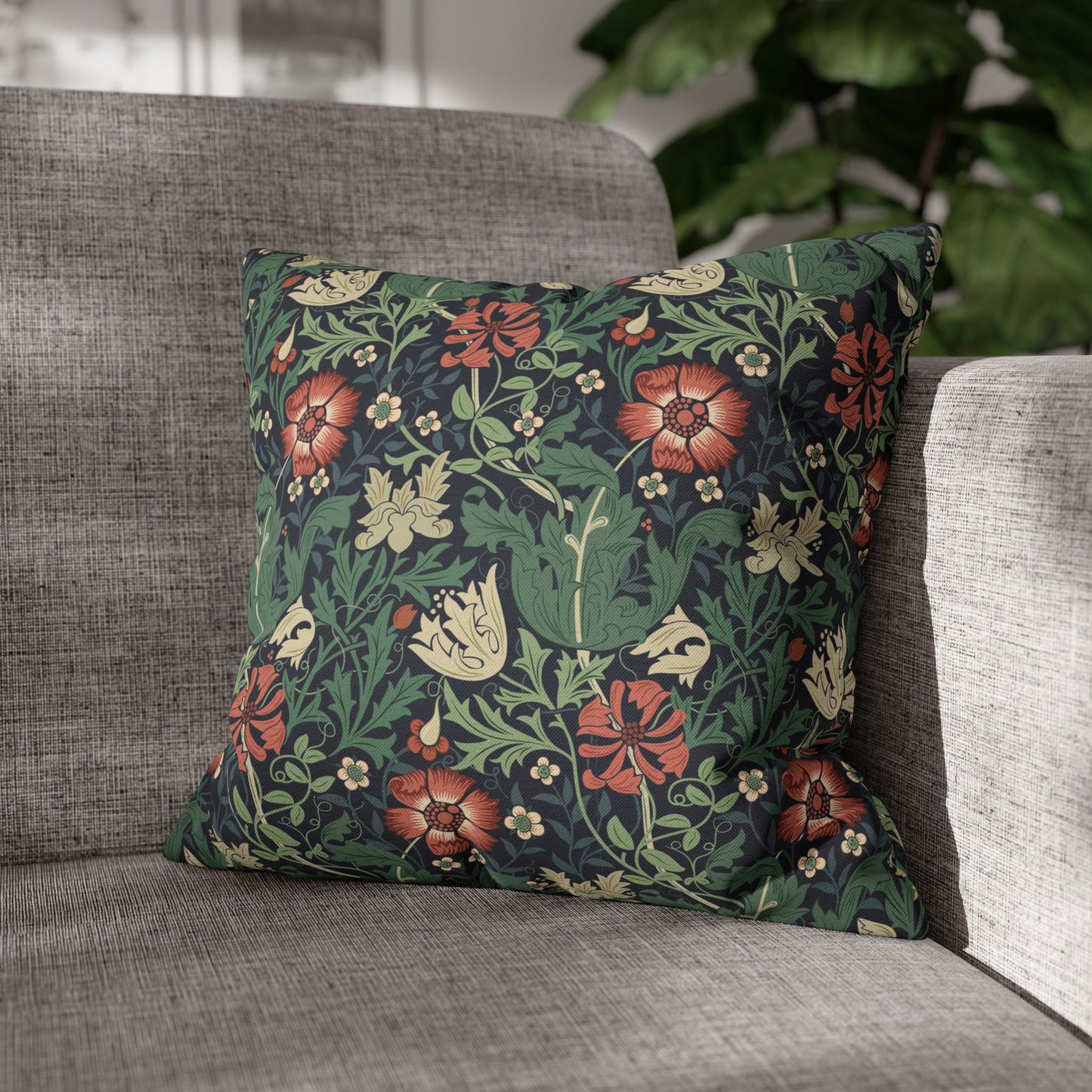 Floral patterned pillow on a gray sofa with a blurred background