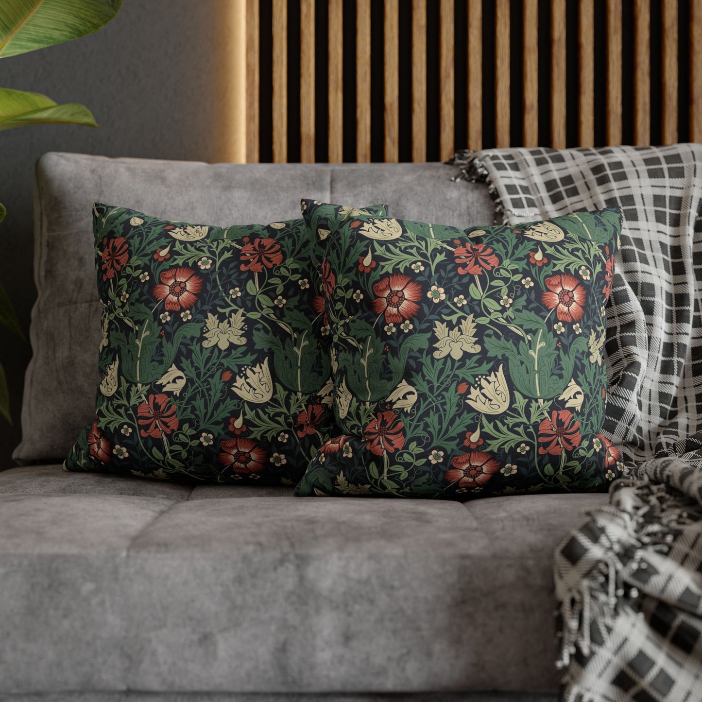 Floral patterned cushions on a gray sofa with a wooden headboard in the background.