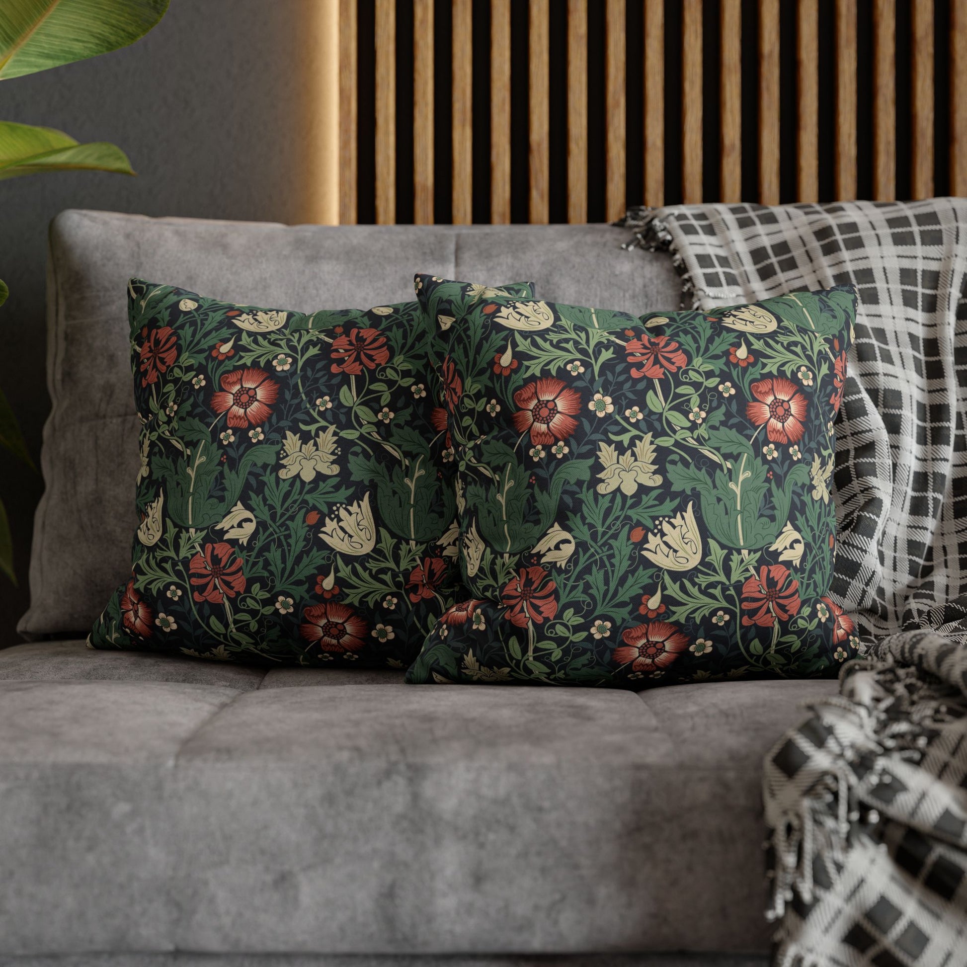 Floral patterned cushions on a gray sofa with a wooden headboard in the background.