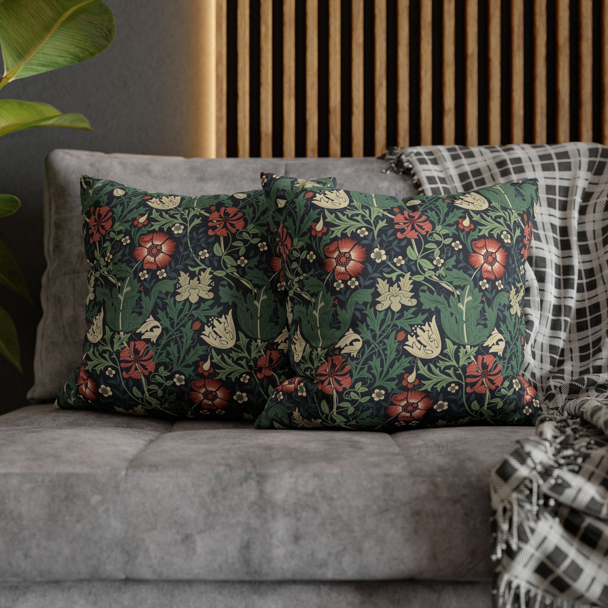 Floral patterned cushions on a gray sofa with a wooden headboard in the background.