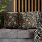 Decorative pillows with floral patterns on a gray sofa against a wooden slat wall.