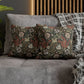 Floral patterned cushions on a gray sofa with a wooden headboard in the background