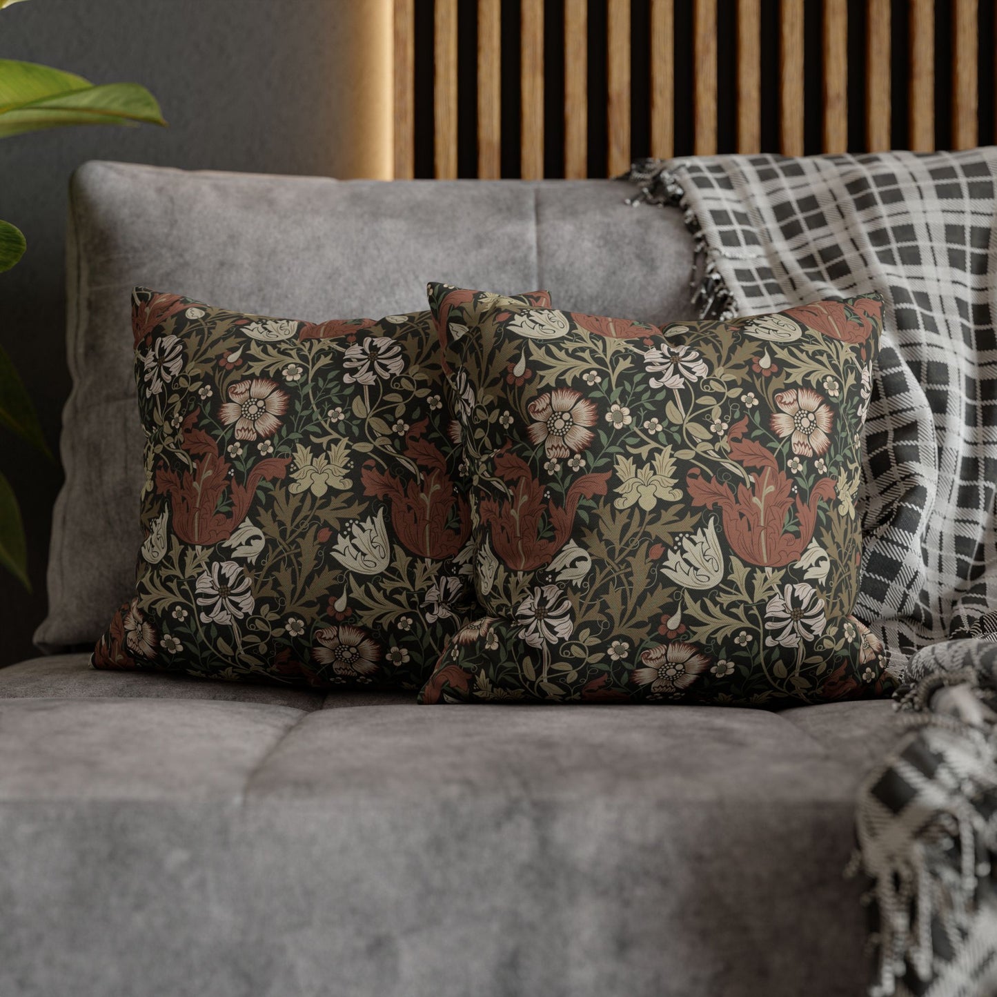 Floral patterned cushions on a gray sofa with a wooden headboard in the background