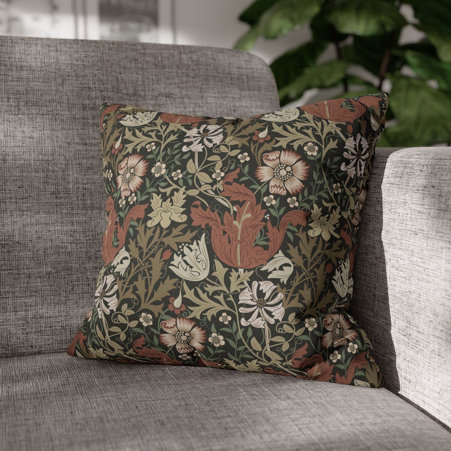 Decorative floral pillow on a gray sofa with a blurred background