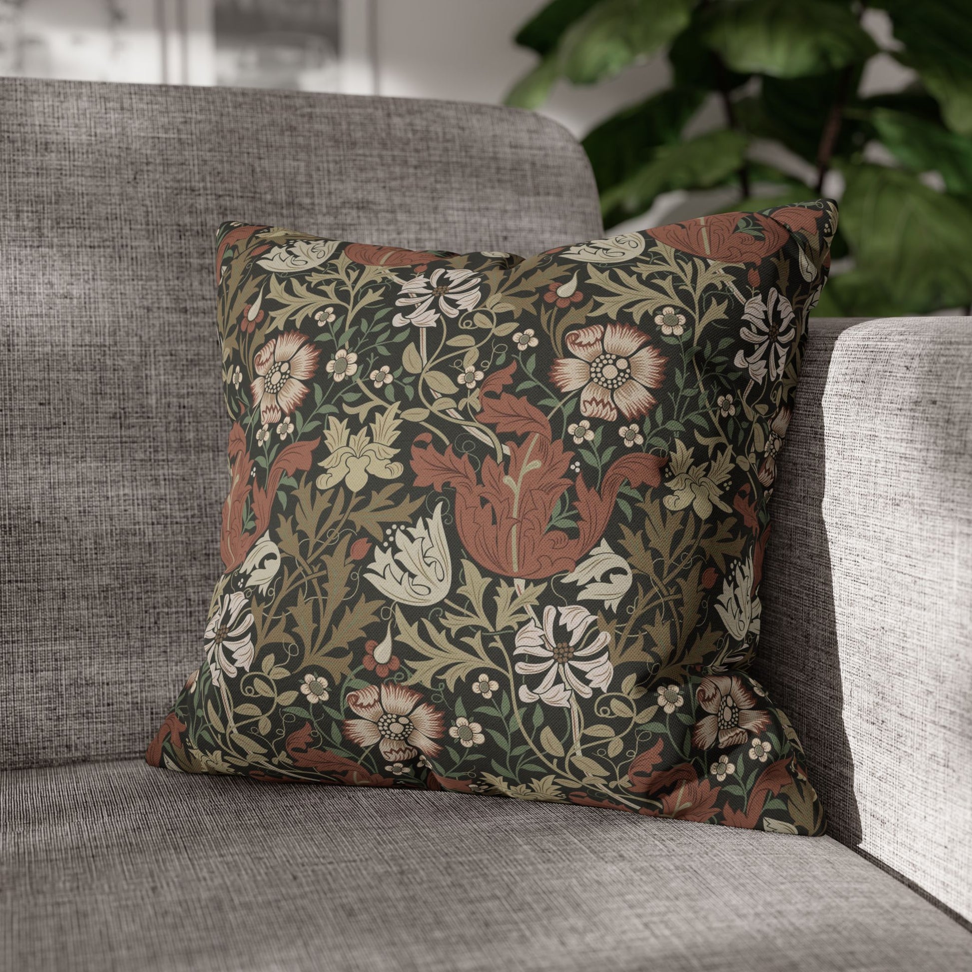 Decorative floral pillow on a gray sofa with a blurred background