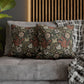 Floral patterned cushions on a gray sofa with a wooden headboard in the background