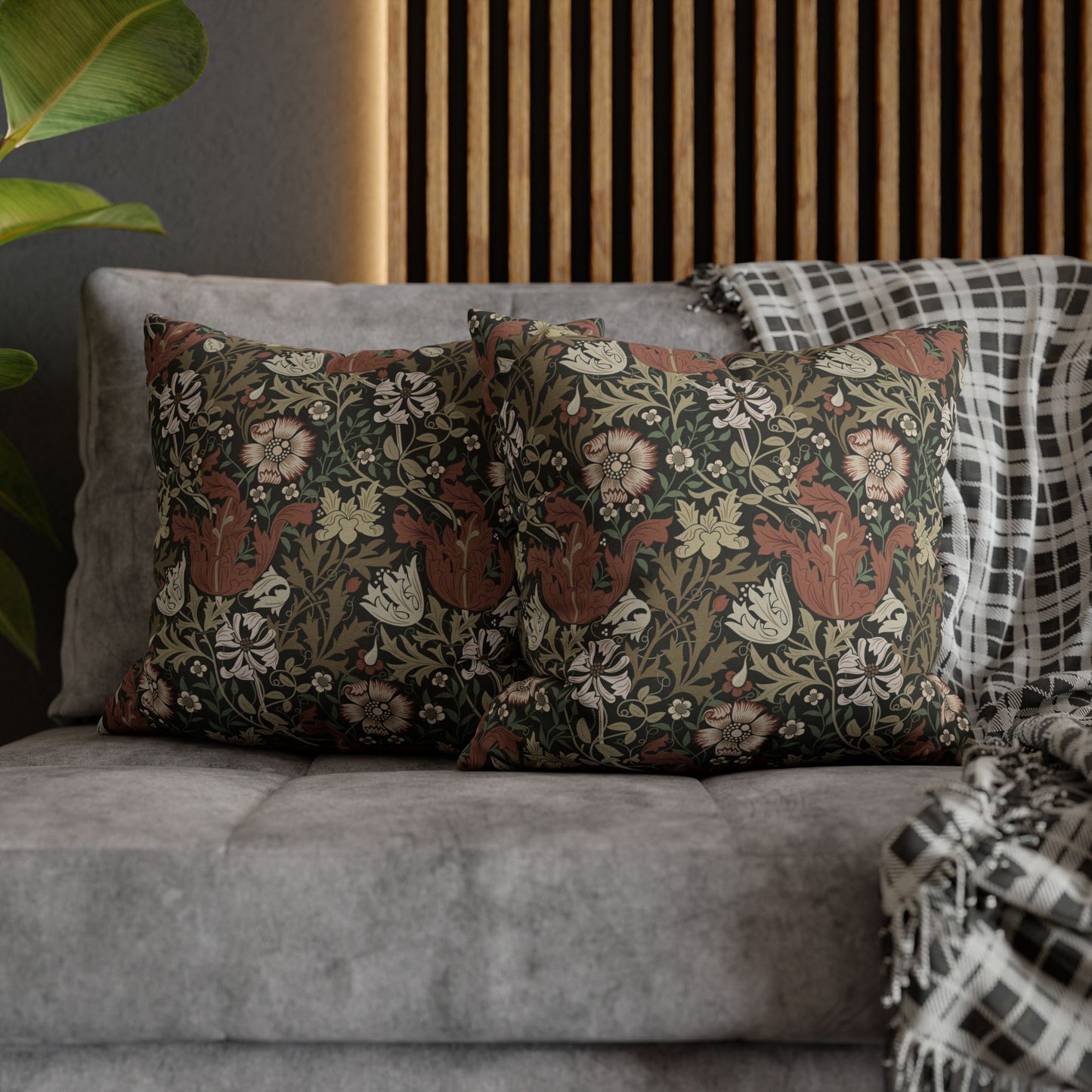 Floral patterned cushions on a gray sofa with a wooden headboard in the background