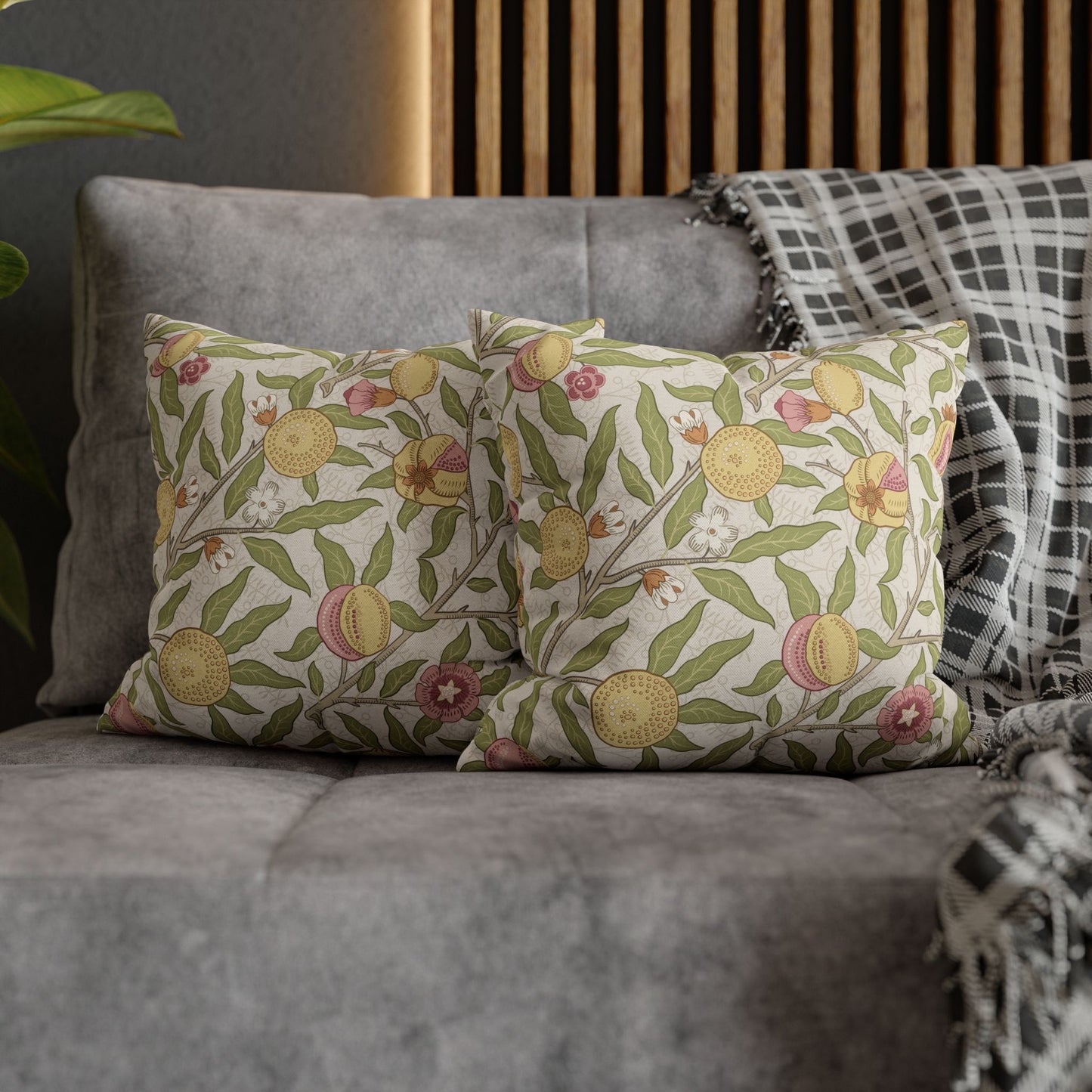 Floral patterned cushions on a gray sofa with a wooden headboard in the background.