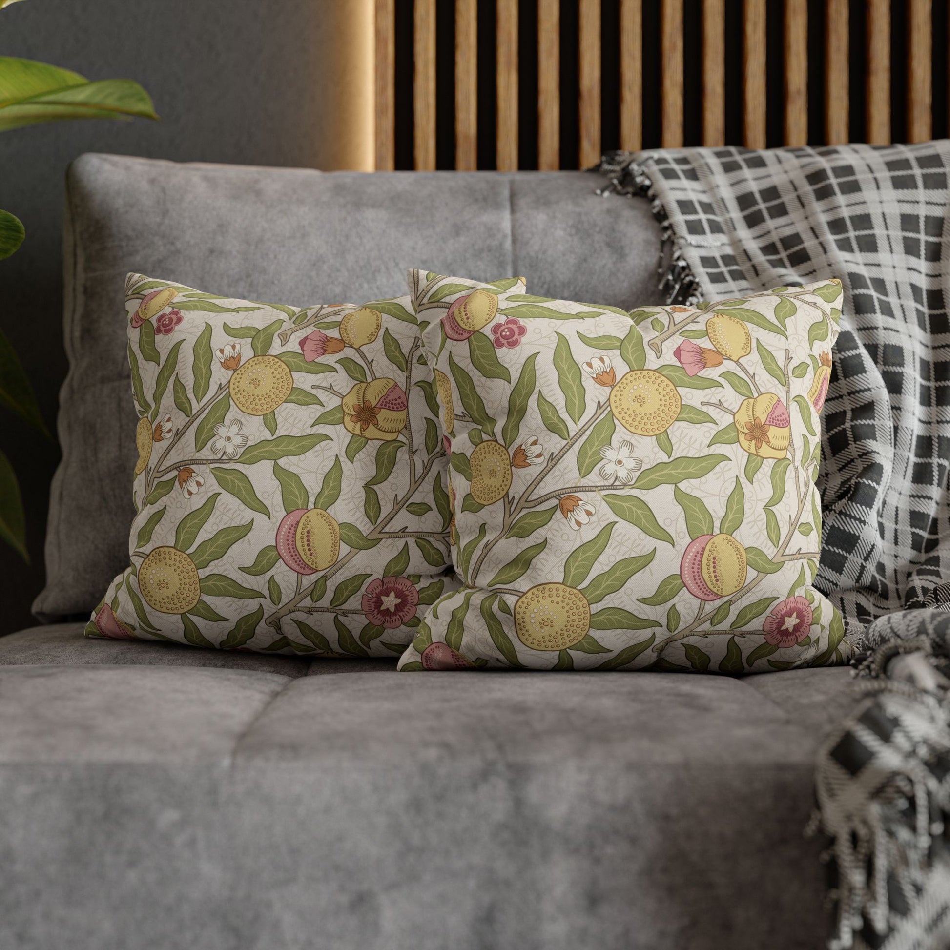 Floral patterned cushions on a gray sofa with a wooden headboard in the background.