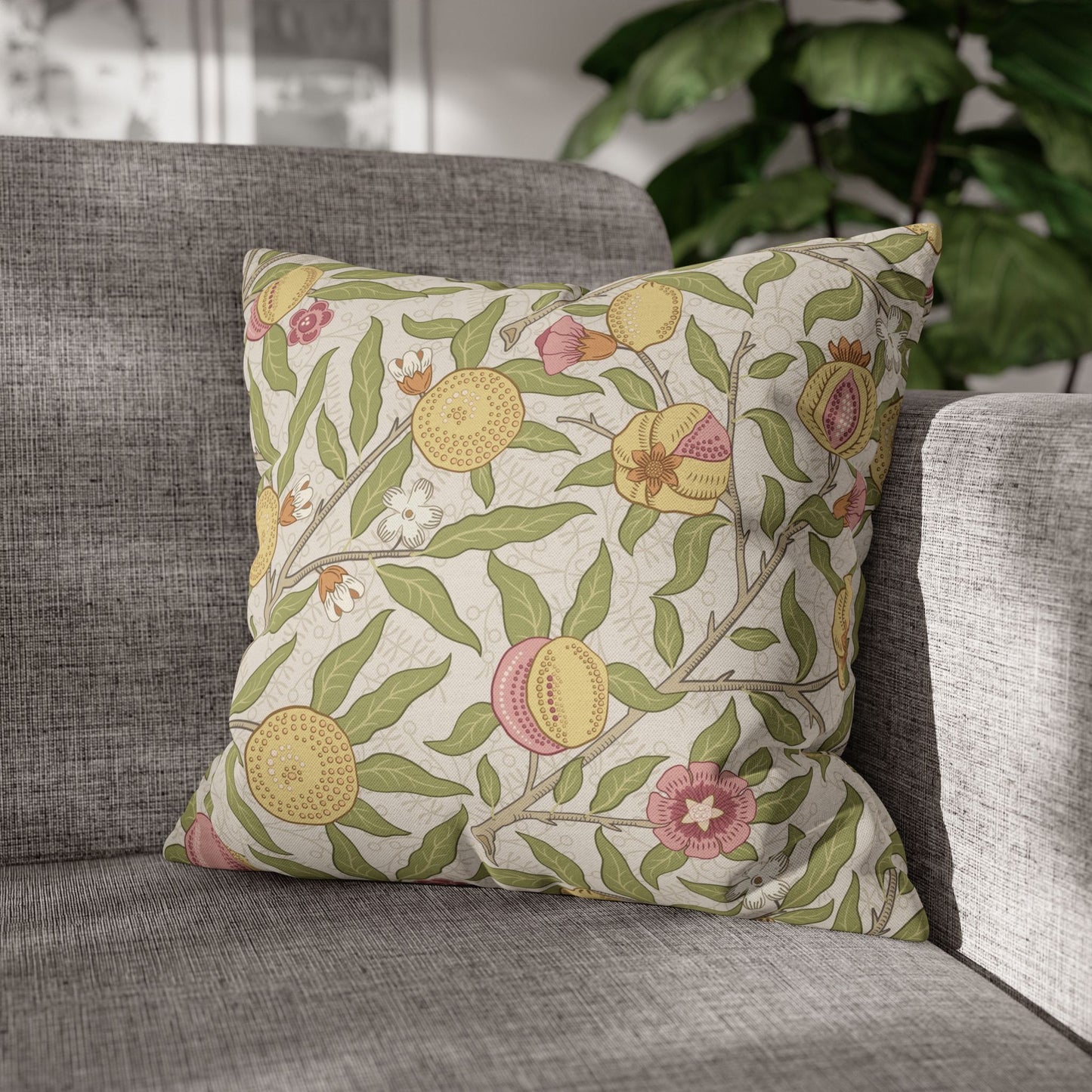Decorative pillow with floral and fruit pattern on a gray sofa