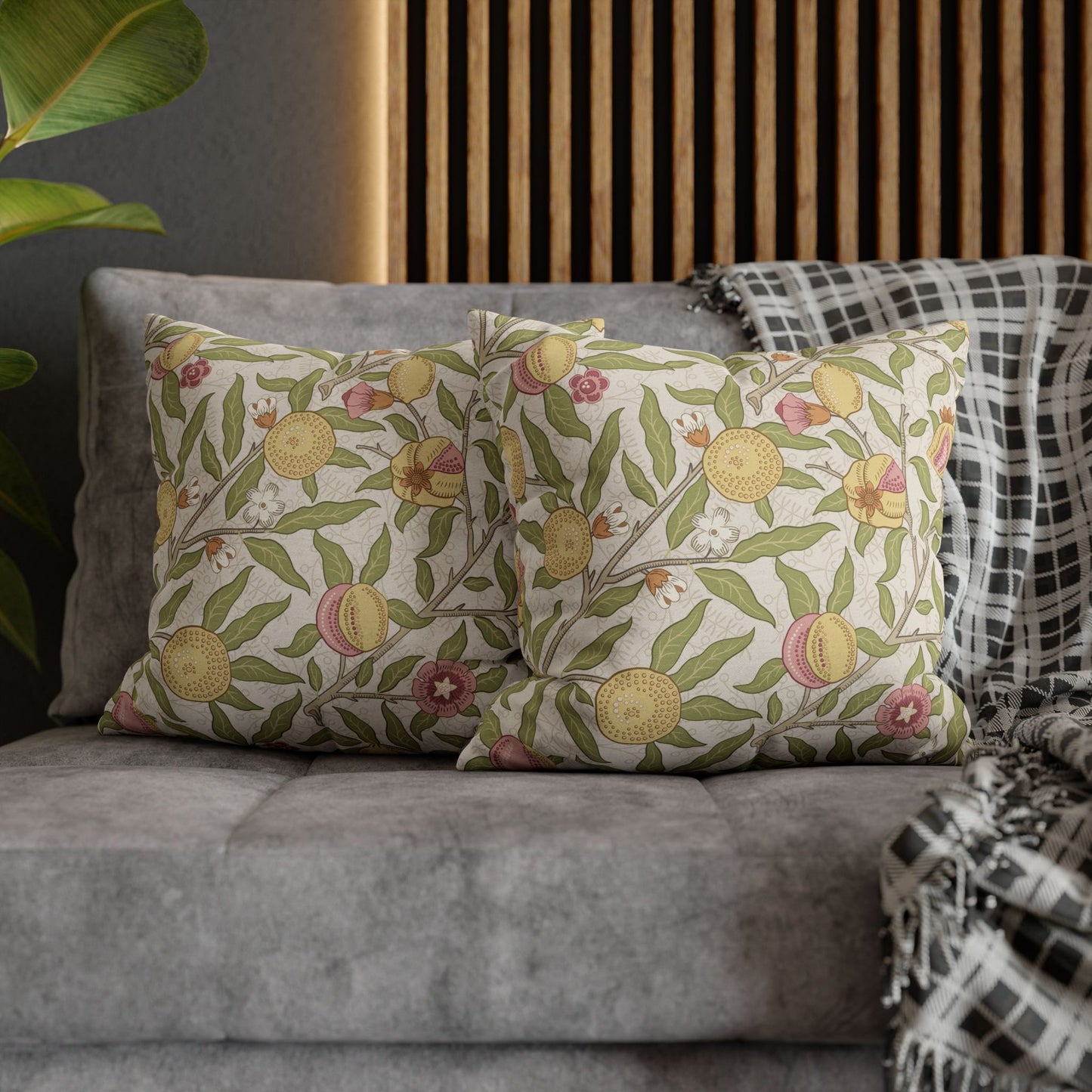 Decorative pillows with floral patterns on a gray sofa against a wooden headboard.