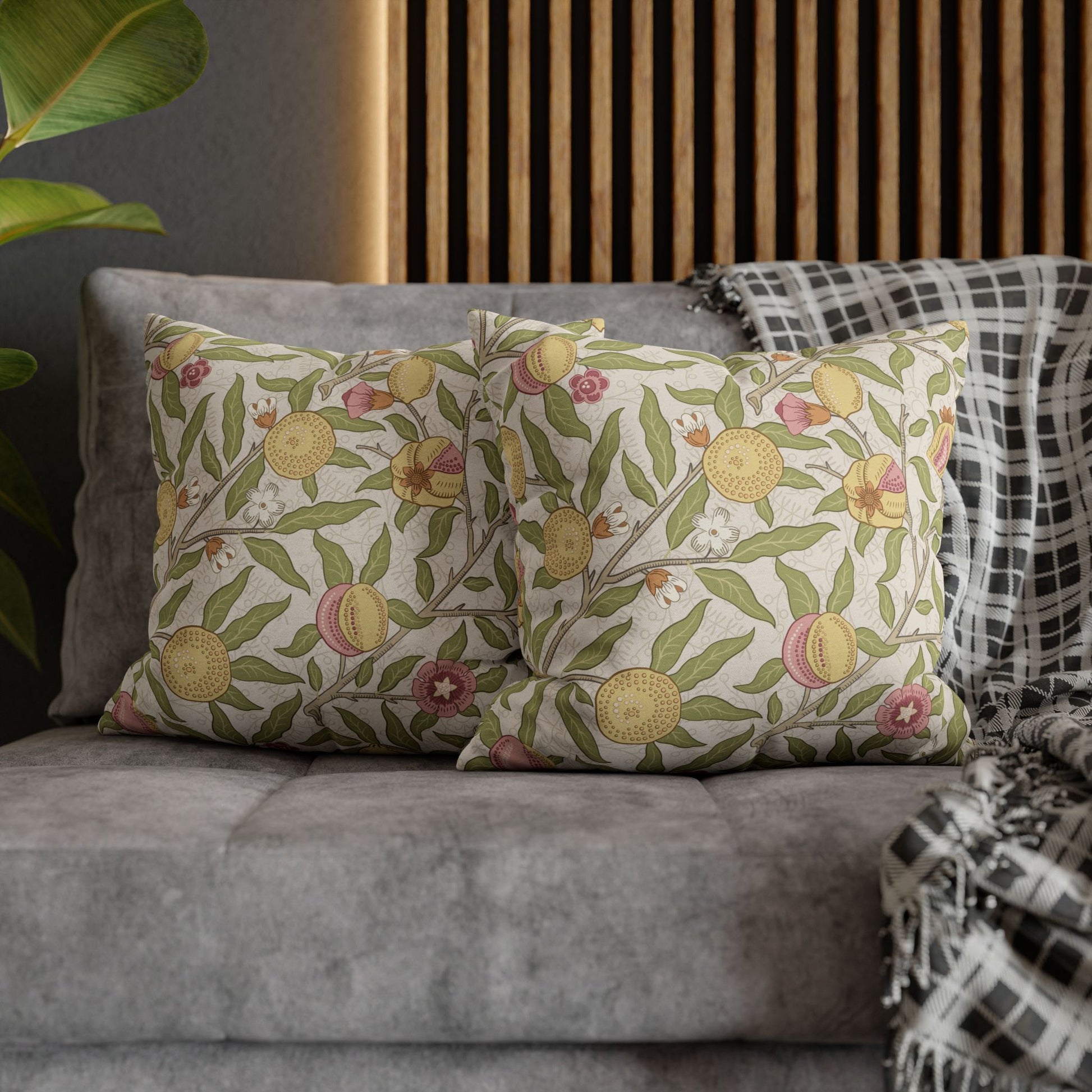 Decorative pillows with floral patterns on a gray sofa against a wooden headboard.