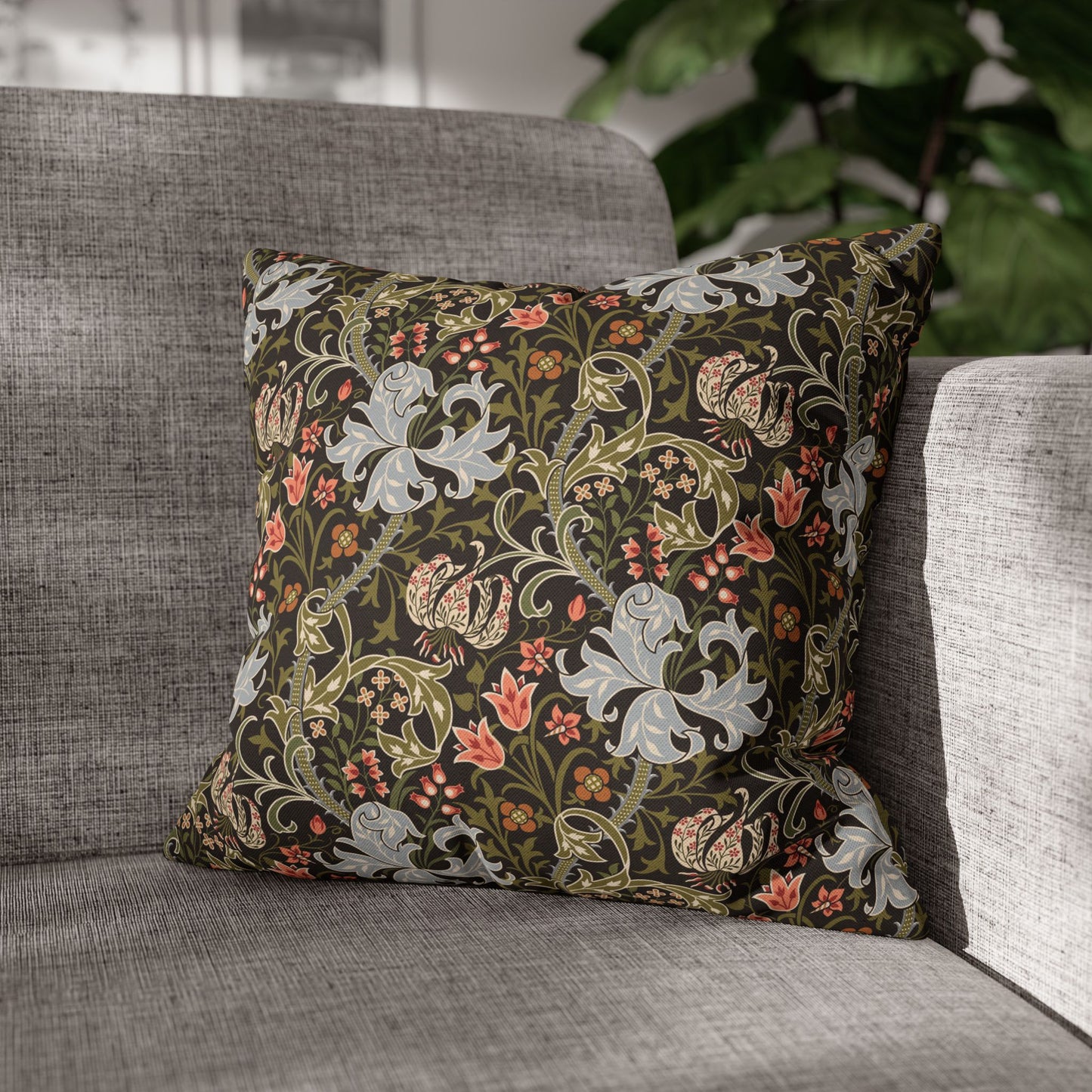 Decorative floral pillow on a gray sofa with a blurred background