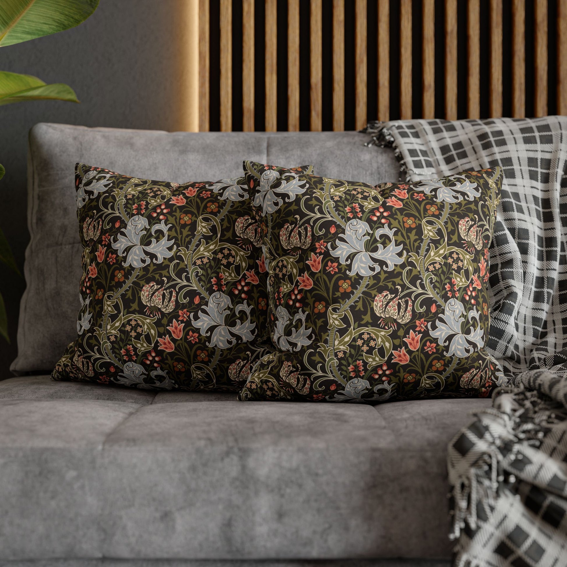 Decorative pillows with floral patterns on a gray sofa.