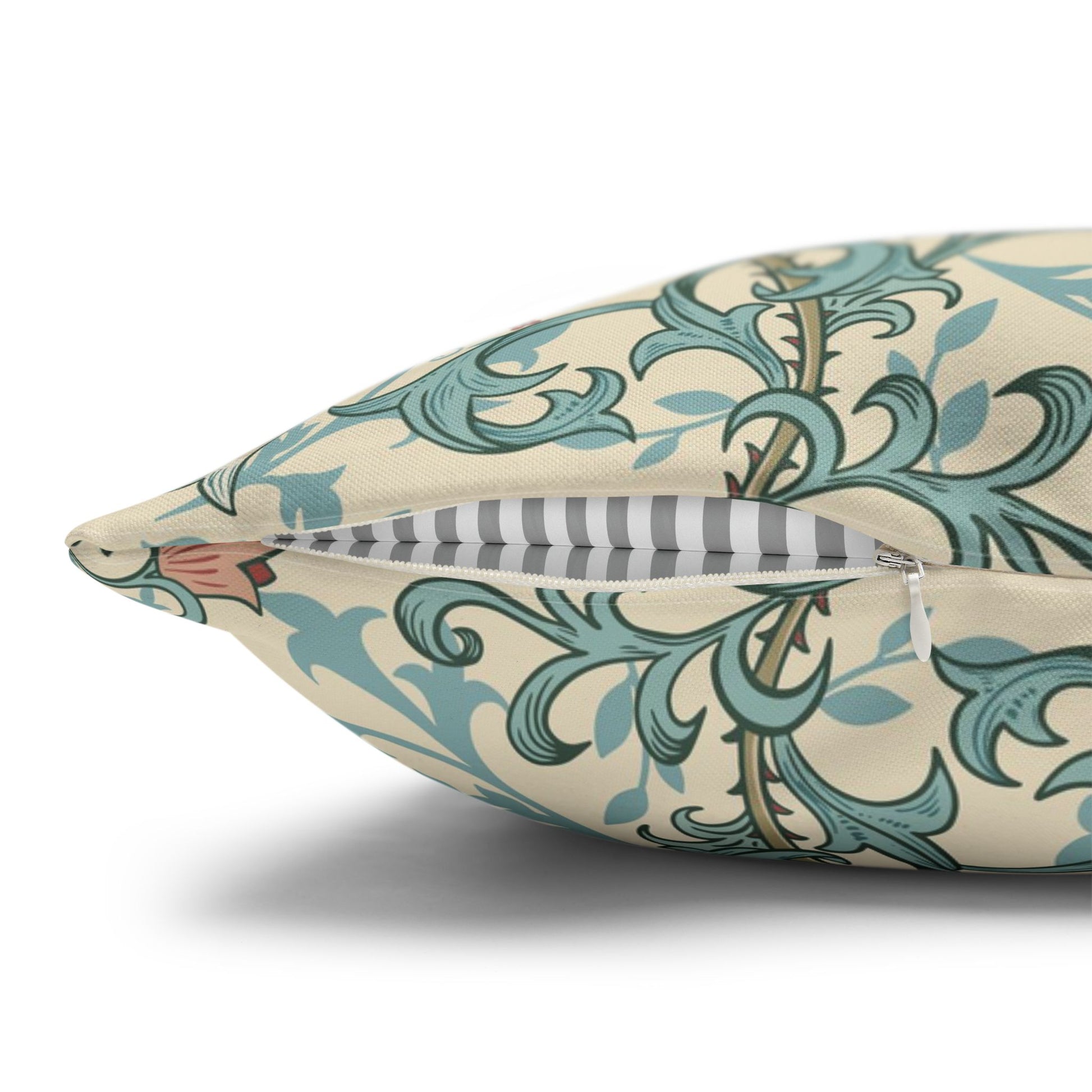 Decorative pillow with teal and beige pattern on a white background