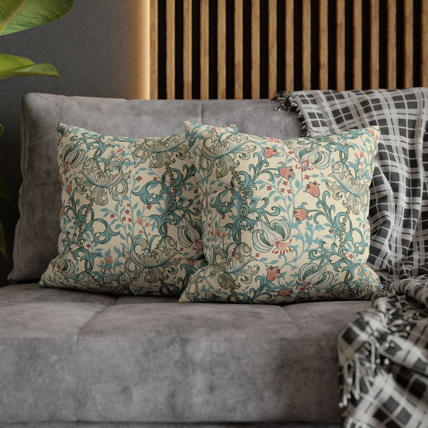 Decorative pillows with floral patterns on a gray sofa against a wooden panel background.