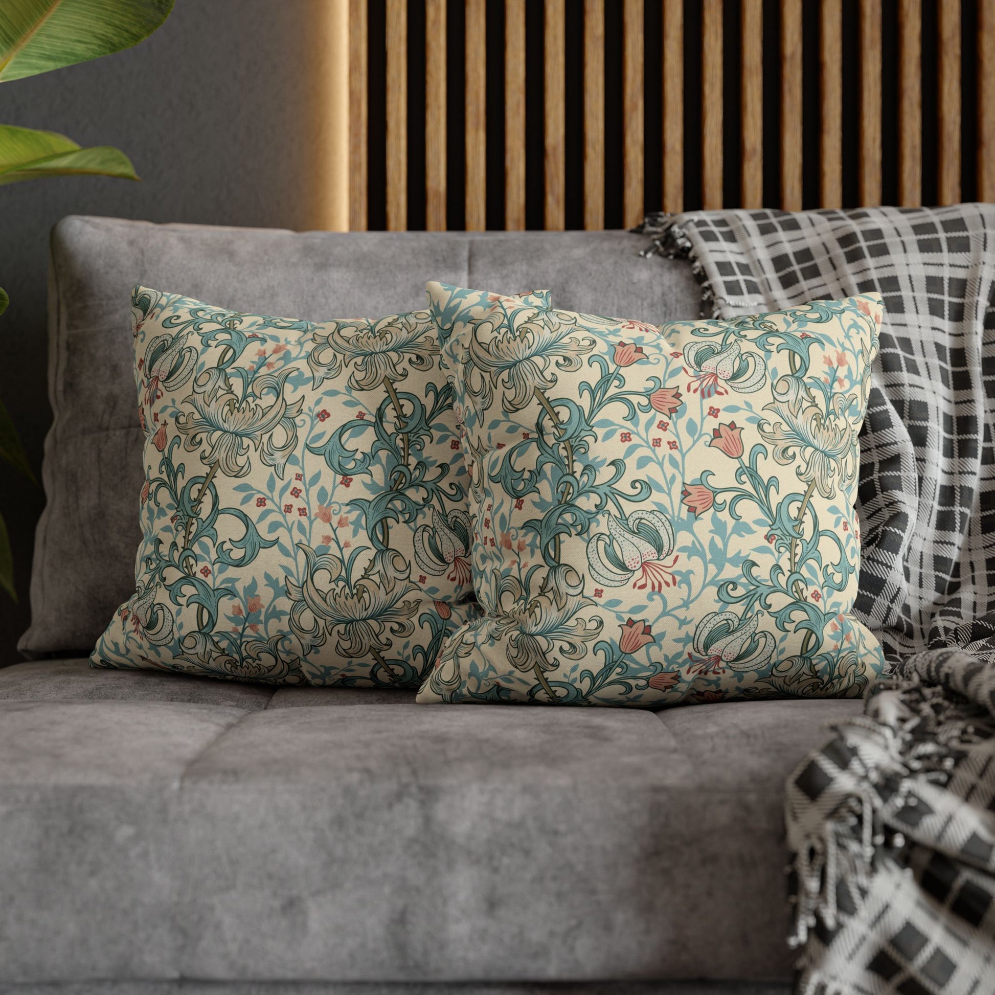 Decorative pillows with floral patterns on a gray sofa against a wooden panel background.
