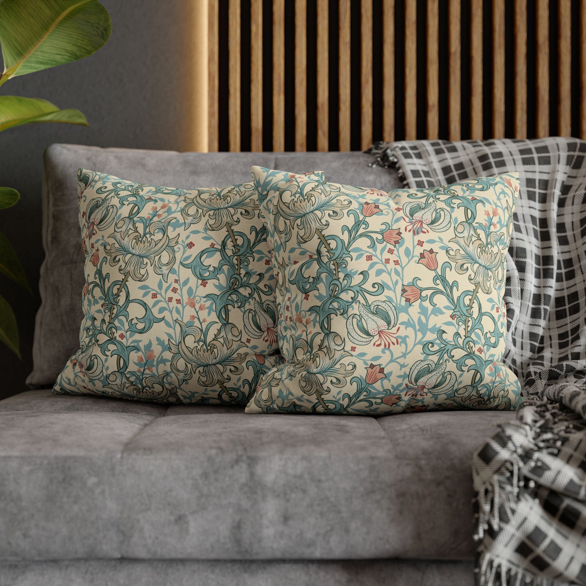 Decorative pillows with floral patterns on a gray sofa against a wooden headboard.