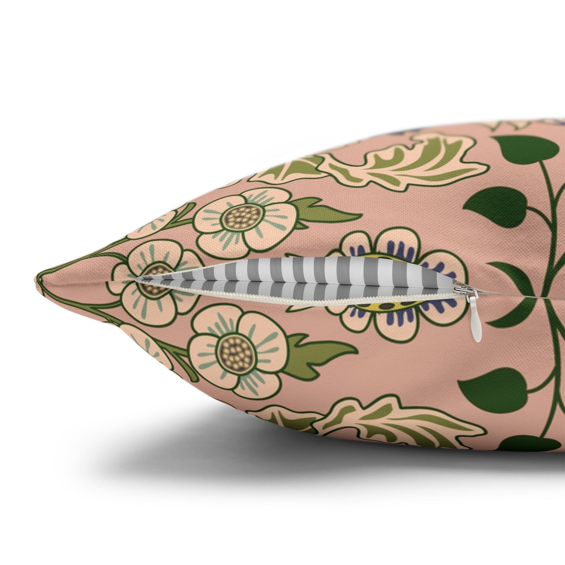 Floral-patterned pillow with a feather on a white background