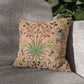 Floral-patterned pillow on a gray sofa with a blurred green plant in the background