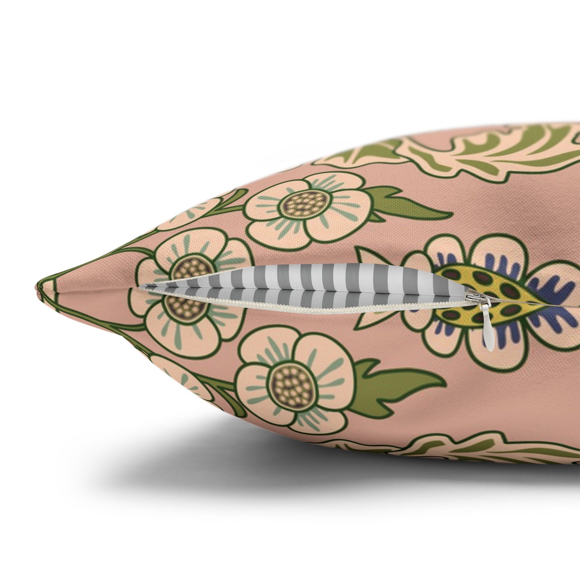 Floral-patterned pillow with a feather on a white background