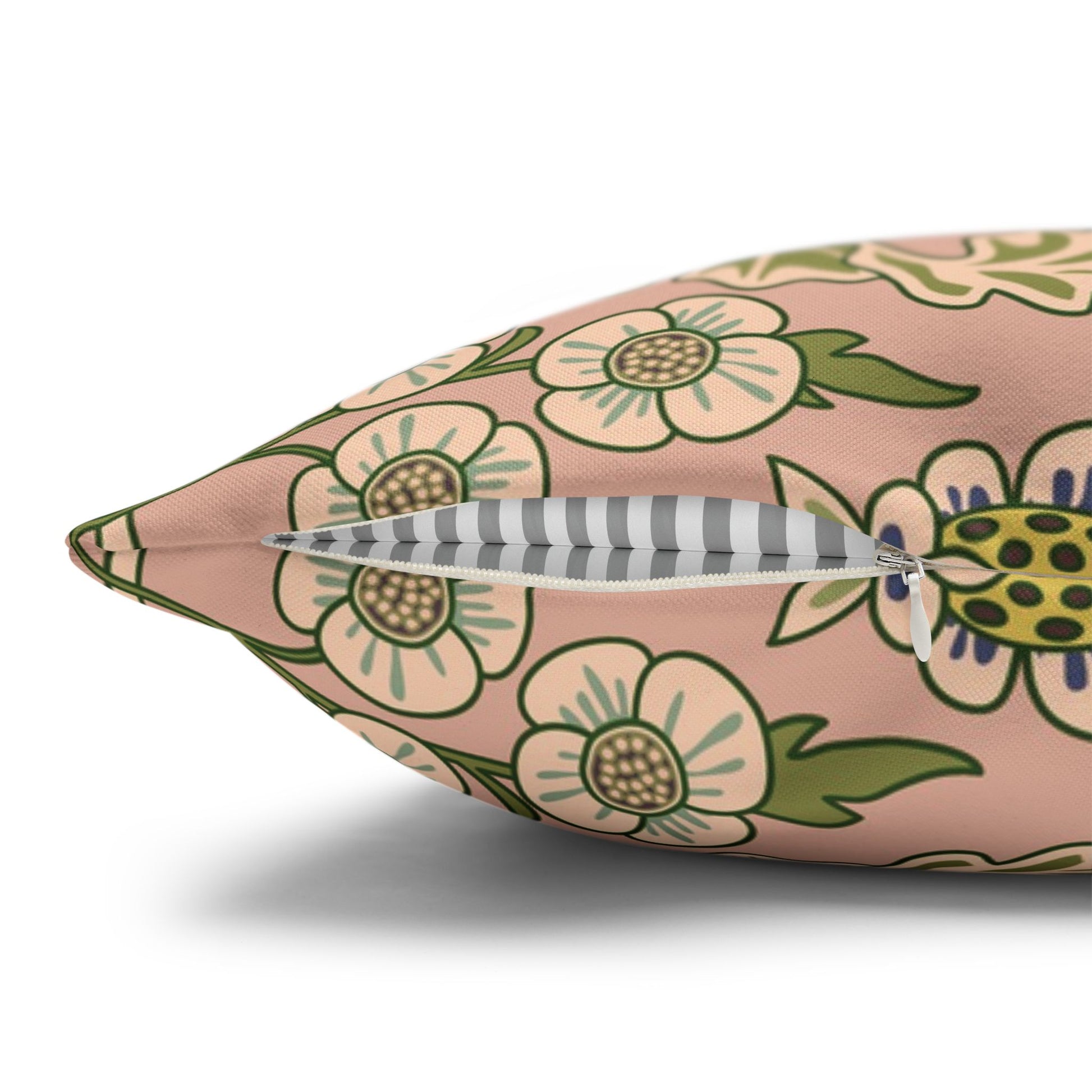 Floral-patterned pillow with a feather on a white background