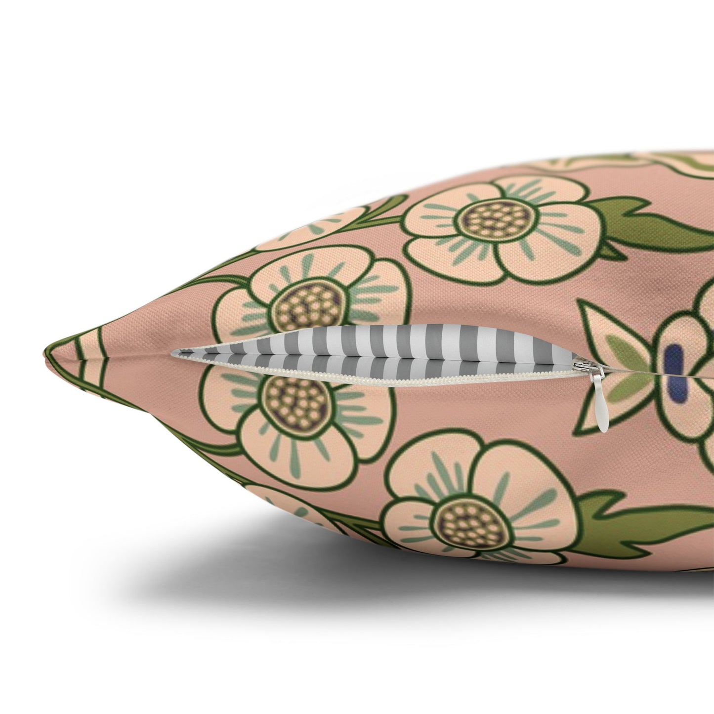 Floral-patterned pillow with a feather on a white background