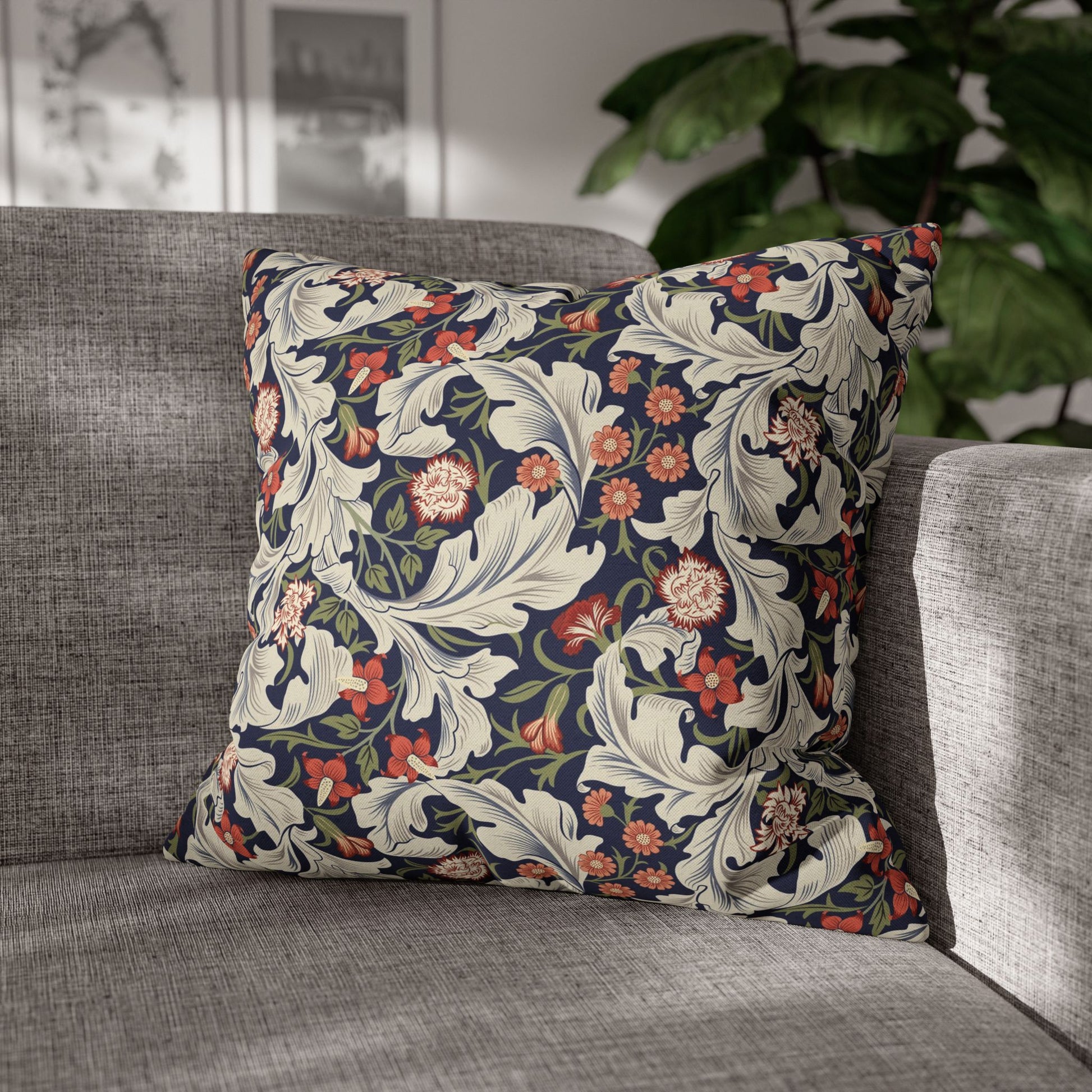 Floral patterned pillow on a gray sofa with a blurred indoor background