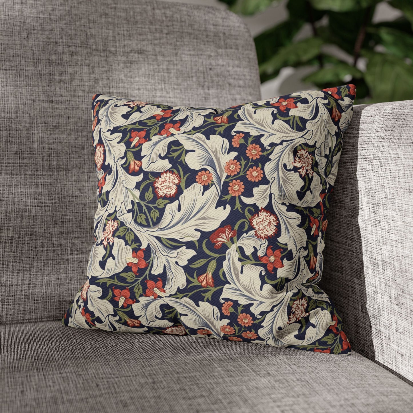 Floral patterned pillow on a gray sofa with a blurred background