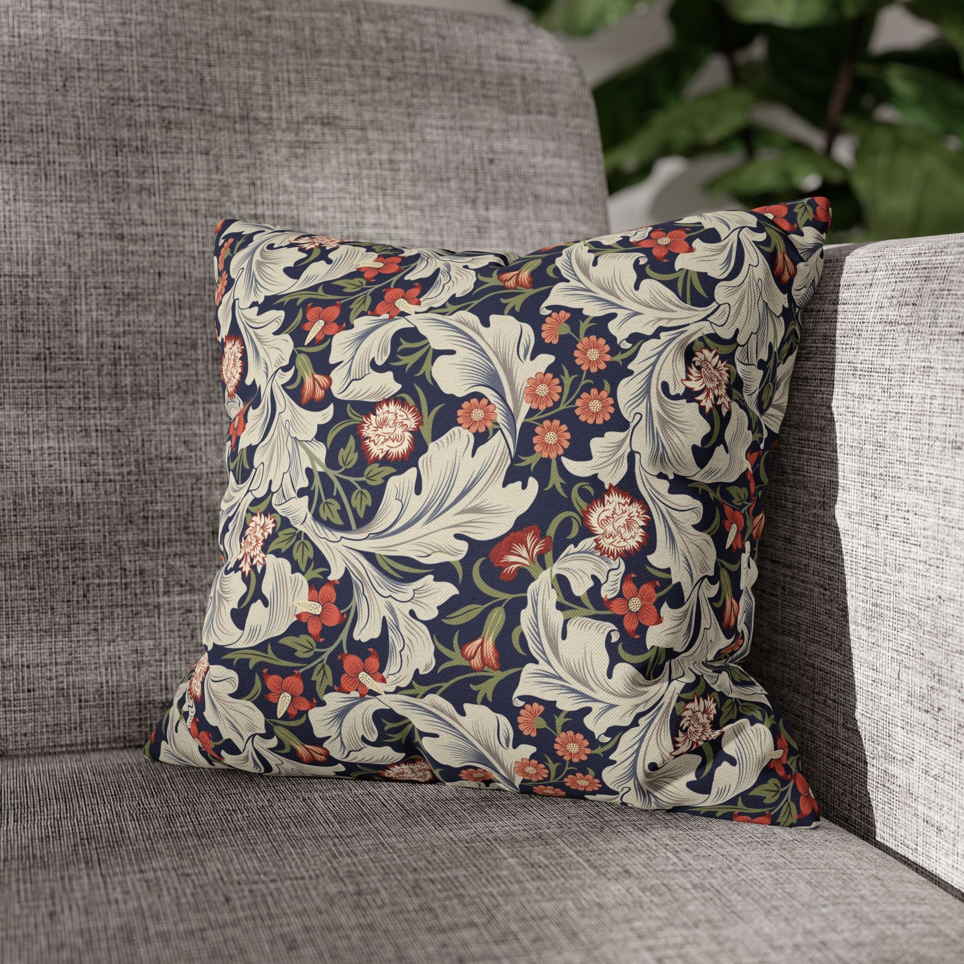 Floral patterned pillow on a gray sofa with a blurred background