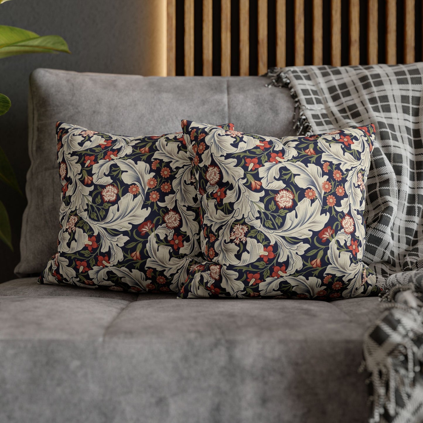 Floral patterned cushions on a gray sofa with a wooden headboard in the background.