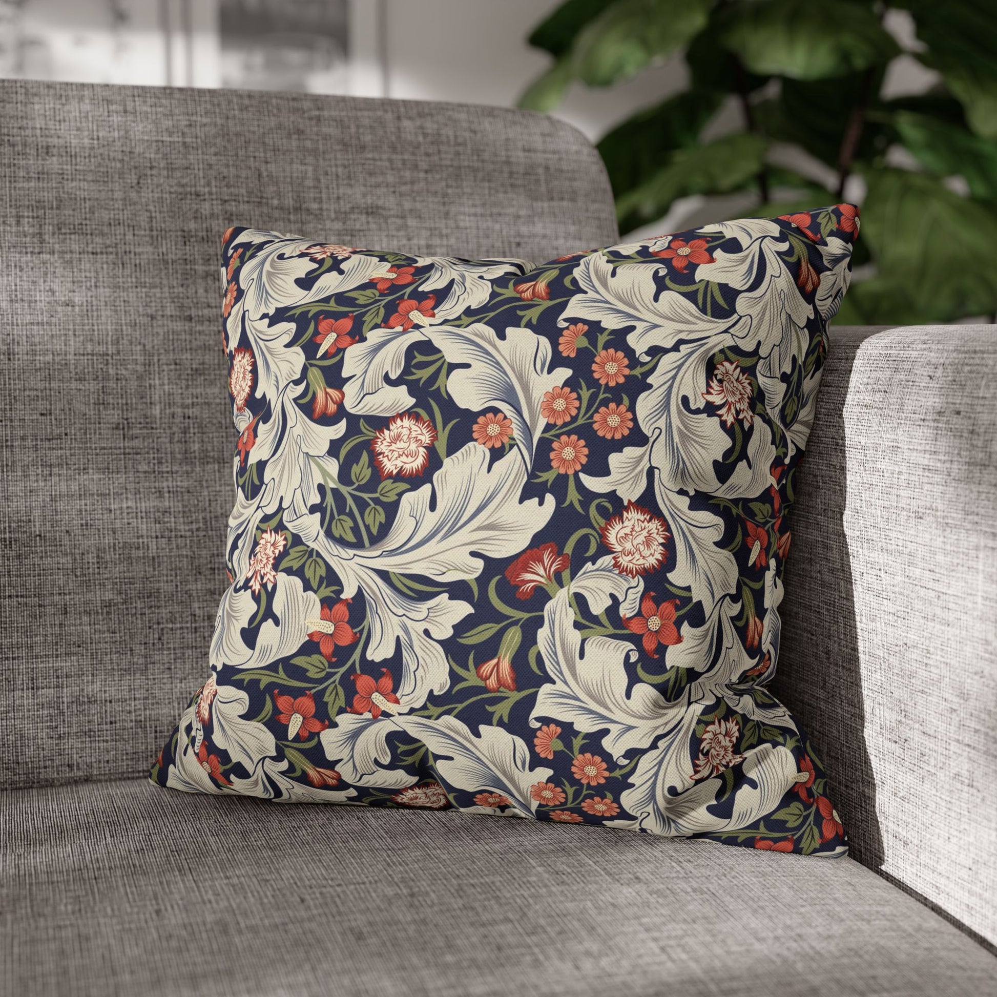 Decorative floral pillow on a gray sofa with a blurred background