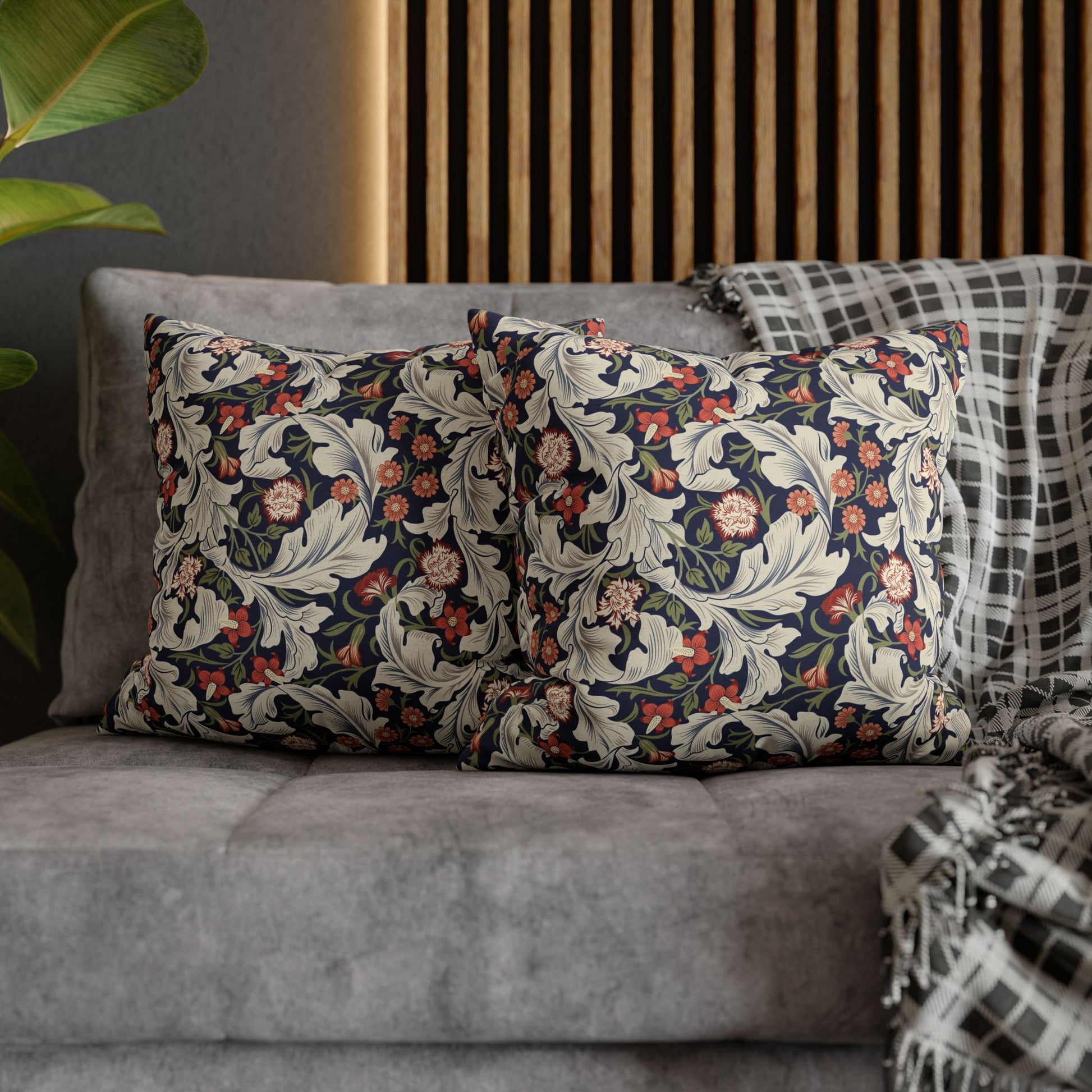 Decorative pillows with floral patterns on a gray sofa against a wooden headboard.