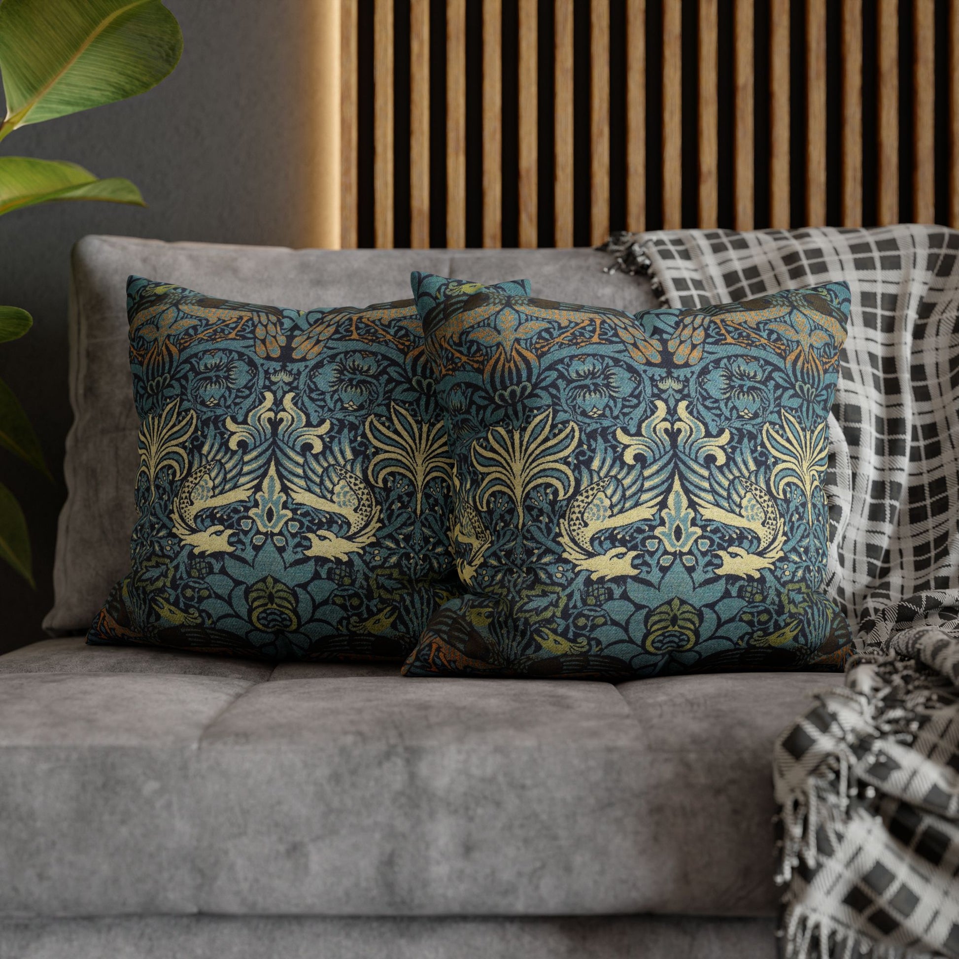 Decorative pillows with intricate patterns on a gray sofa against a wooden panel wall.