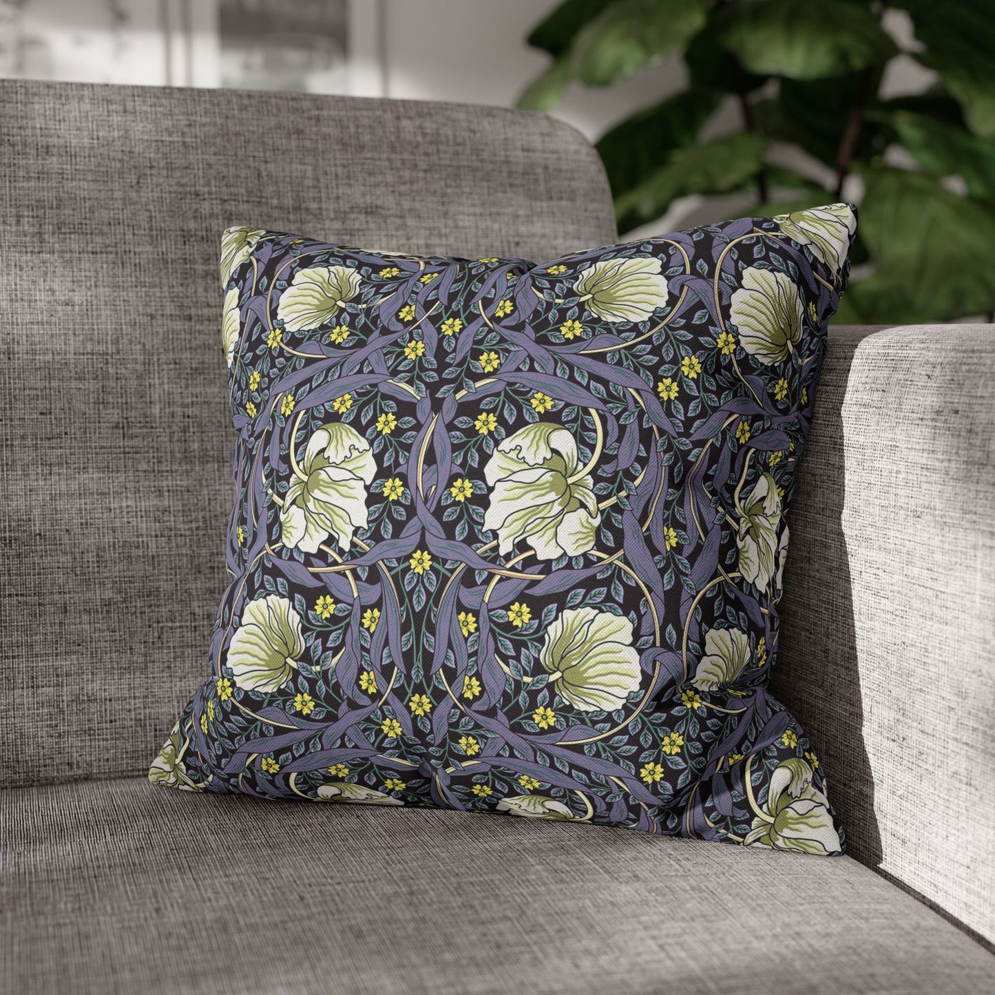Floral patterned pillow on a gray sofa with a blurred background