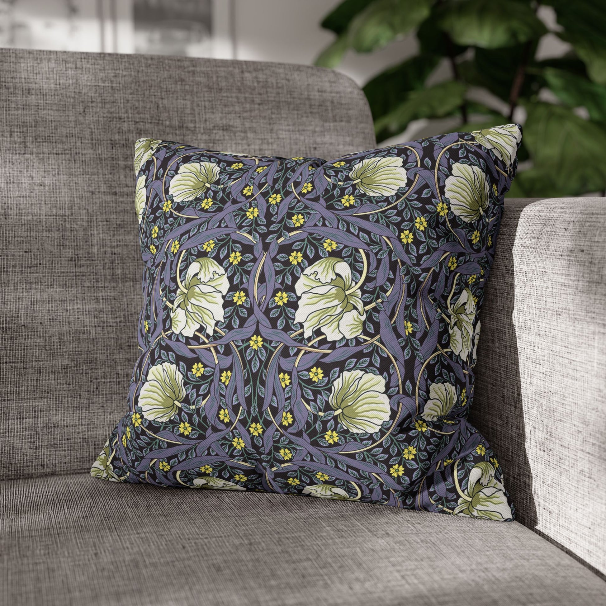 Floral patterned pillow on a gray sofa with a blurred background