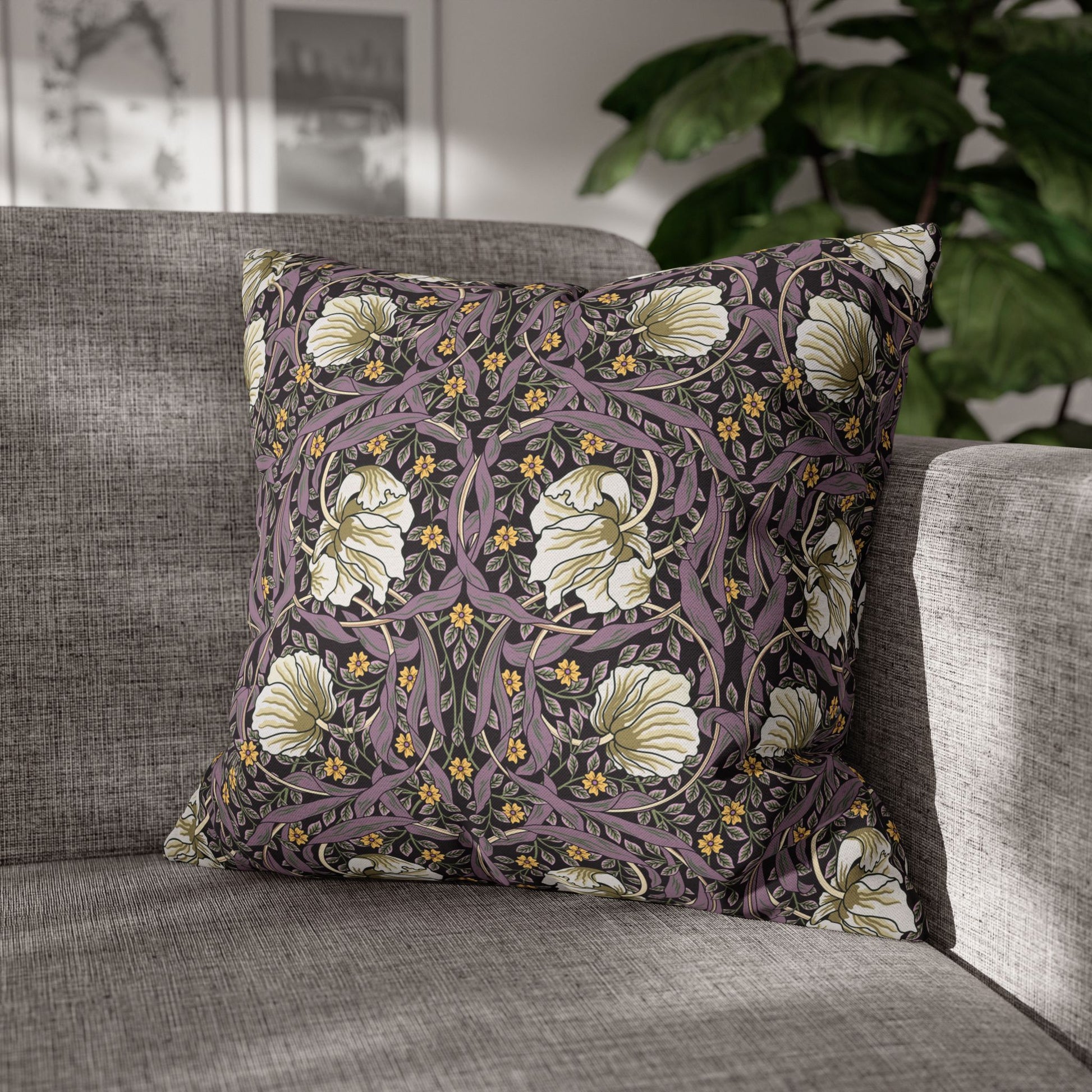 Floral patterned pillow on a gray sofa with a blurred indoor background