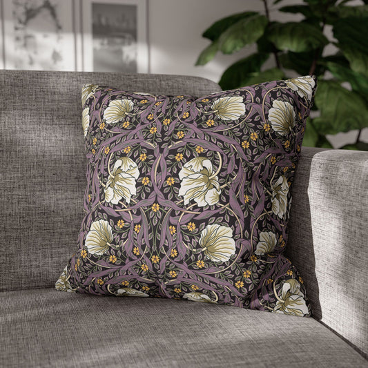 Floral patterned pillow on a gray sofa with a blurred indoor background