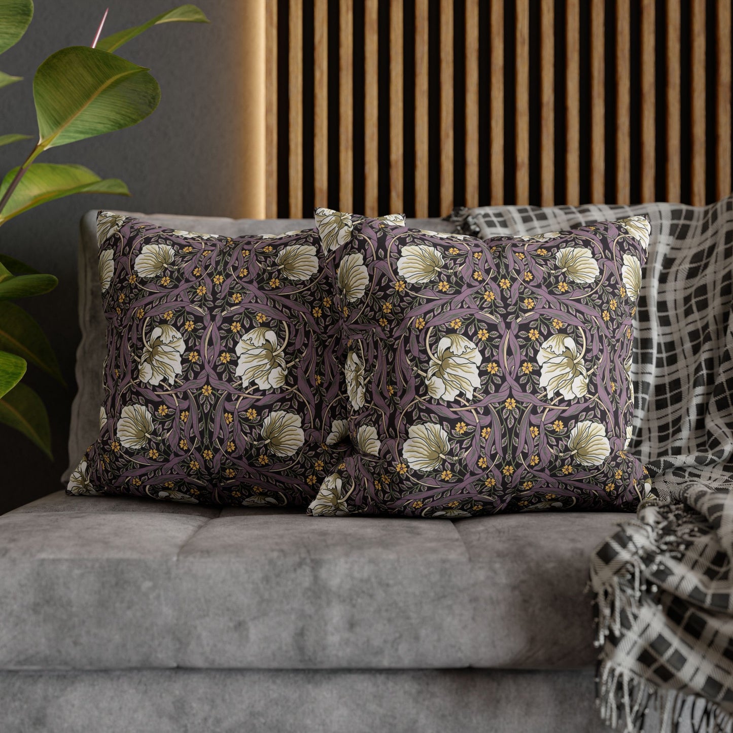 Decorative pillows with floral patterns on a gray sofa.