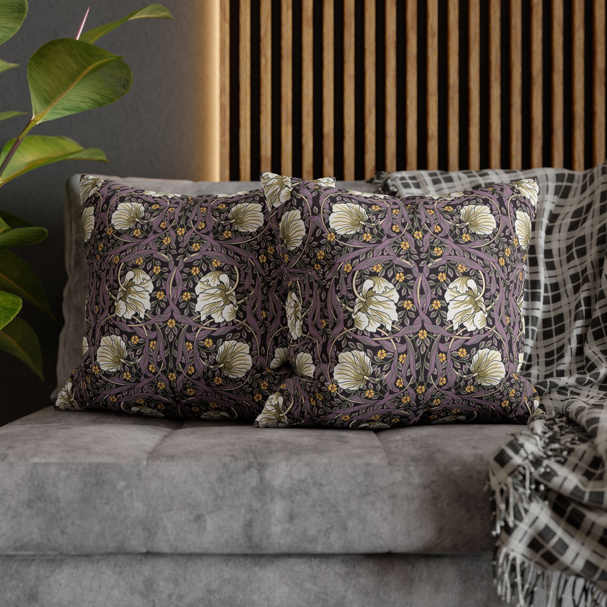 Decorative pillows with floral patterns on a gray sofa.