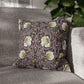 Floral patterned pillow on a gray sofa with a blurred background