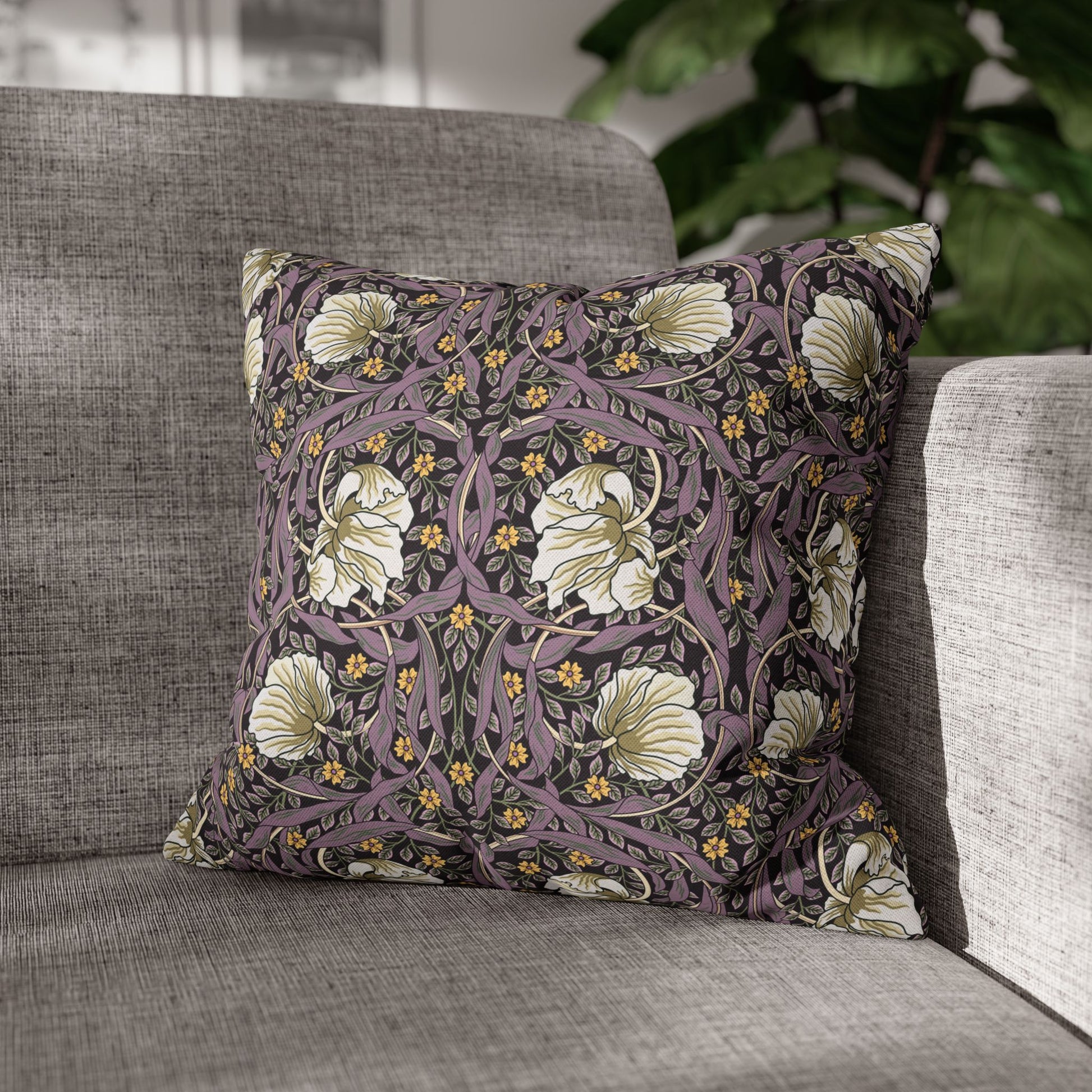 Floral patterned pillow on a gray sofa with a blurred background