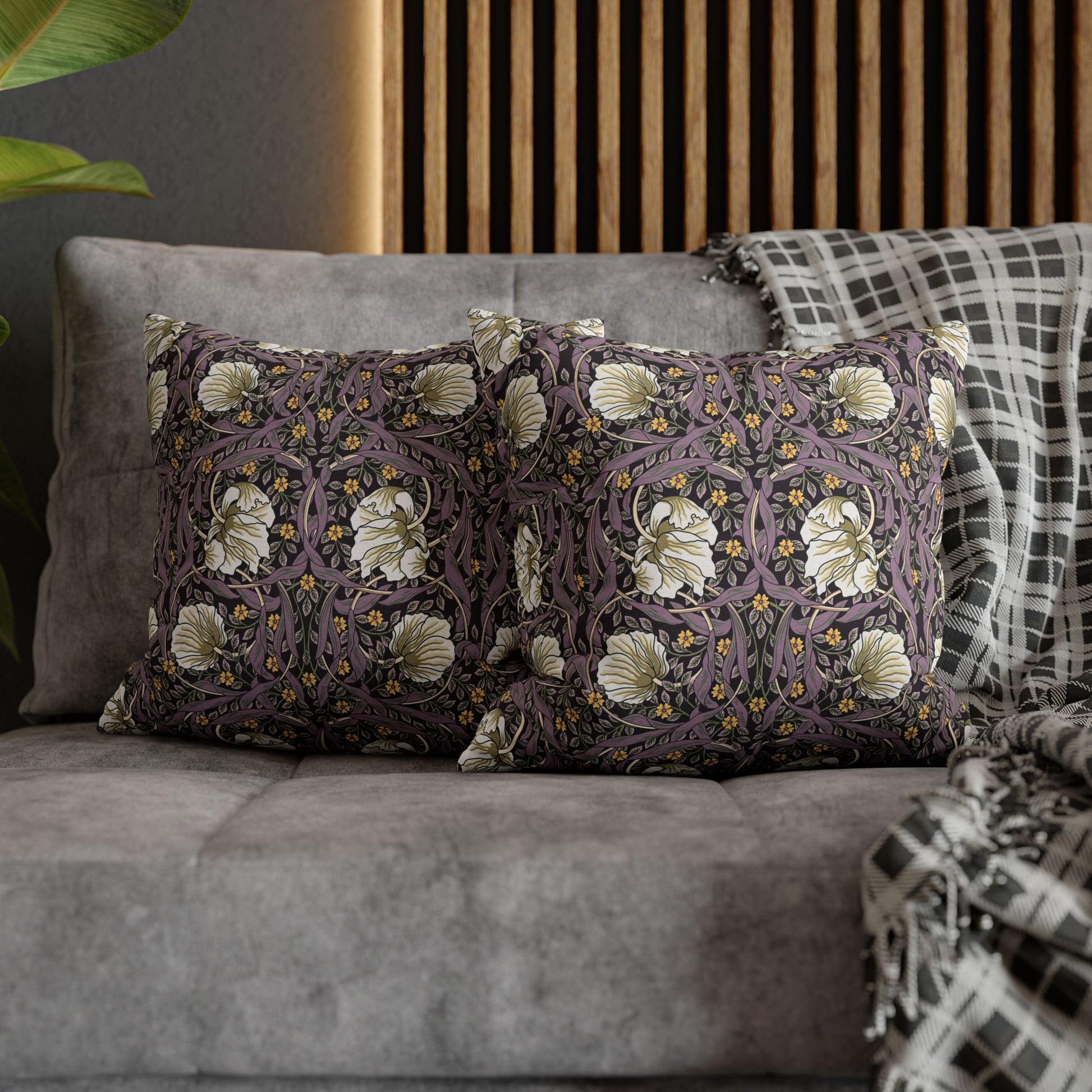 Decorative pillows with floral patterns on a gray sofa.