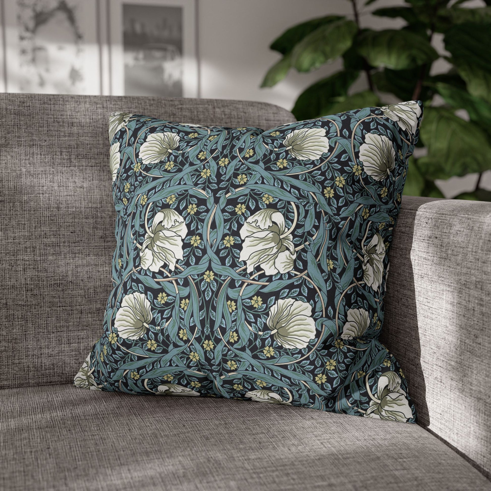 Floral patterned pillow on a gray sofa with a blurred indoor background