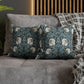 Two decorative pillows with floral patterns on a gray sofa.
