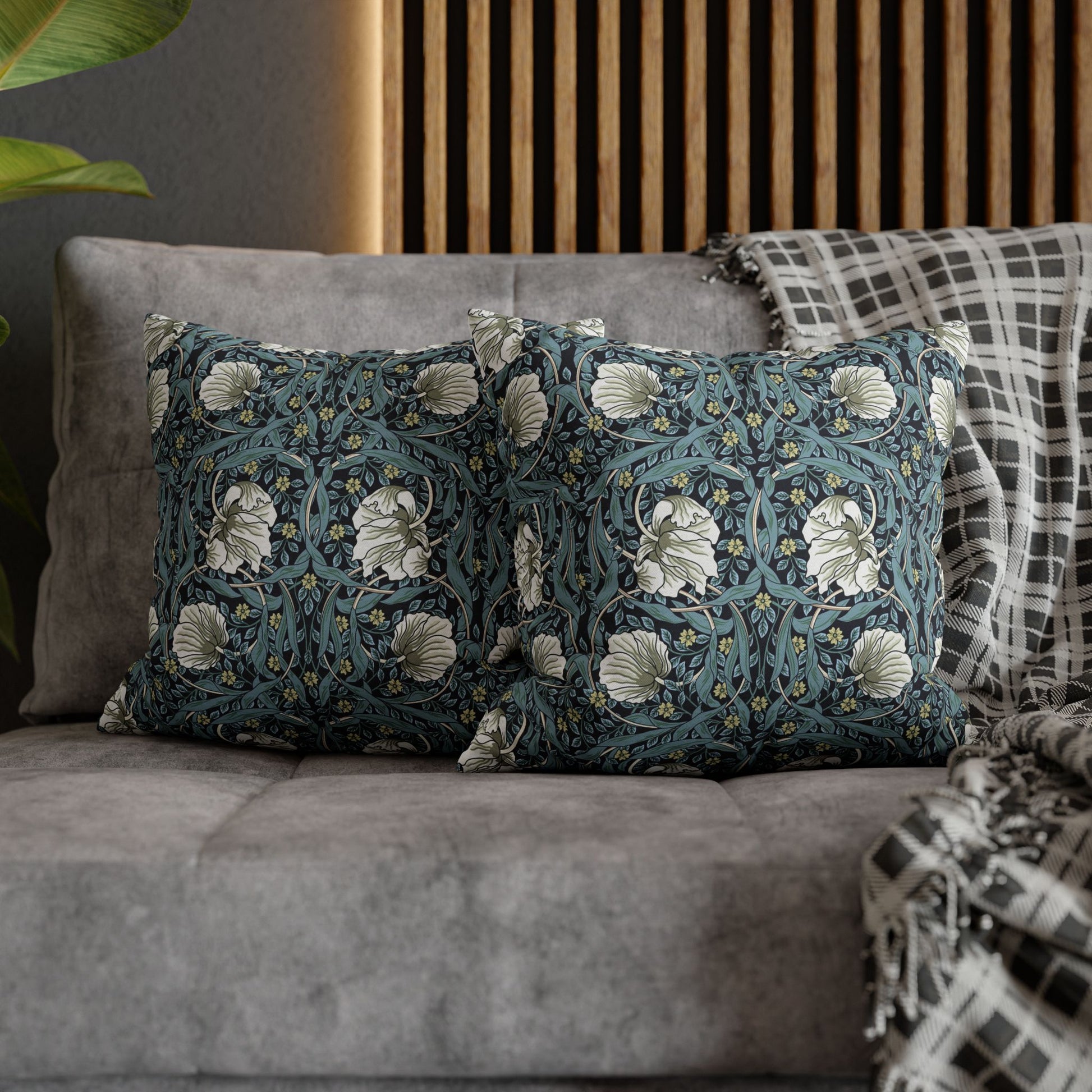 Decorative pillows with floral patterns on a gray sofa.